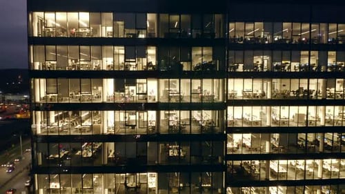 Cinematic Drone View of LateNight Office Life in Glass Skyscrapers