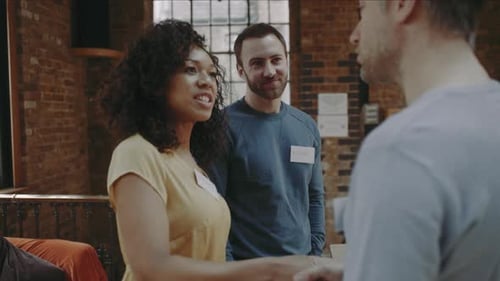 Business People Talking and Shaking Hands Indoors