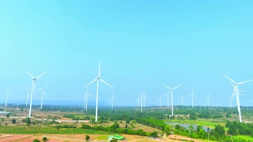 Majestic wind turbines stand tall against a soft sky, aerial view drone.