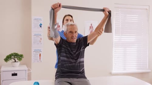 Young Physiotherapist Working with Senior Patient in Rehabilitation Center. Trainer Assisting Senior