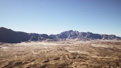 Expansive Brightly Lit Desert Featuring Lone Mountain Ridges and Rugged Ground