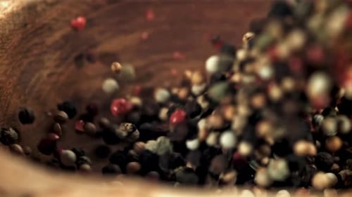 Colorful Pepper Grains Pouring into Bowl