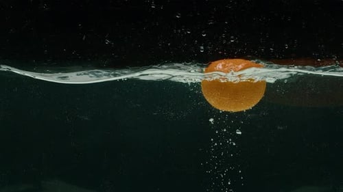 Orange Splashing Into Water in Slow Motion