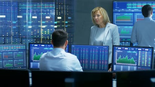 In the Stock Market Selling/ Buying Department Female Manager Talks with Male Trader. In the Backgr