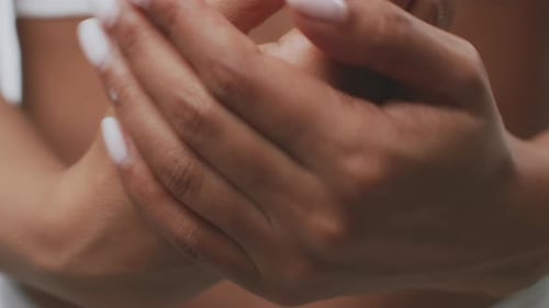 Woman Moisturizing Hands with Lotion in Close Up