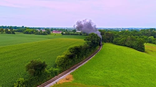An Aerial Following View of an Antique Steam Passenger Train Blowing Black Smoke Thru Pennsylvania F