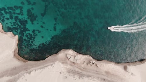 zodiac boat from top aerial shot in shalow clear waters close to the shore in patagonia slowmotion