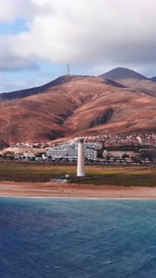 Playa aérea de Fuerteventura con faros, complejos turísticos y colinas
