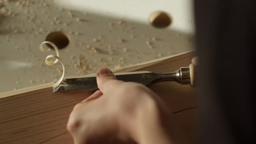 Woodworker chiseling a piece of wood on a table