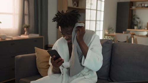 Man in robe looking at phone indoors