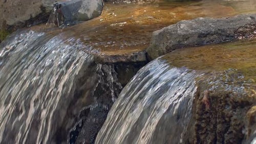 Closeup of water flowing over rocks in a beautiful mountain river cascade