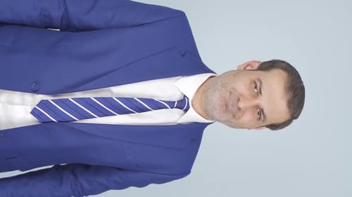 Man in Blue Suit Points to His Jacket