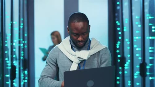 Technician Working in Modern Data Center Server Room