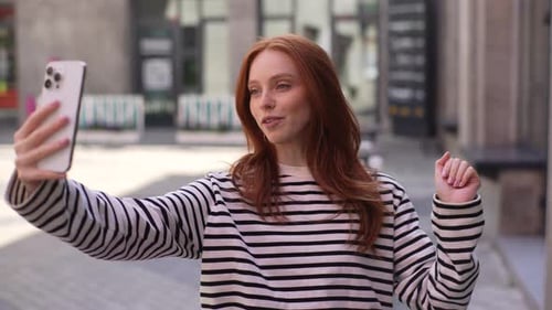 Woman Recording Video on Smartphone in City Street