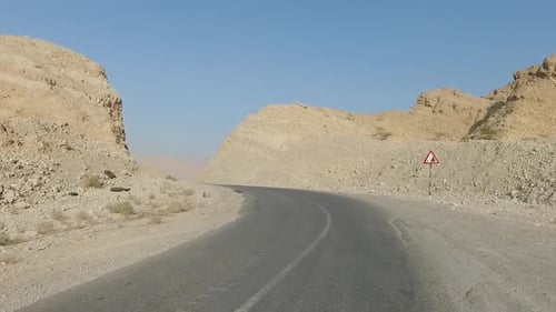 Shot of mountain range and desert road from car