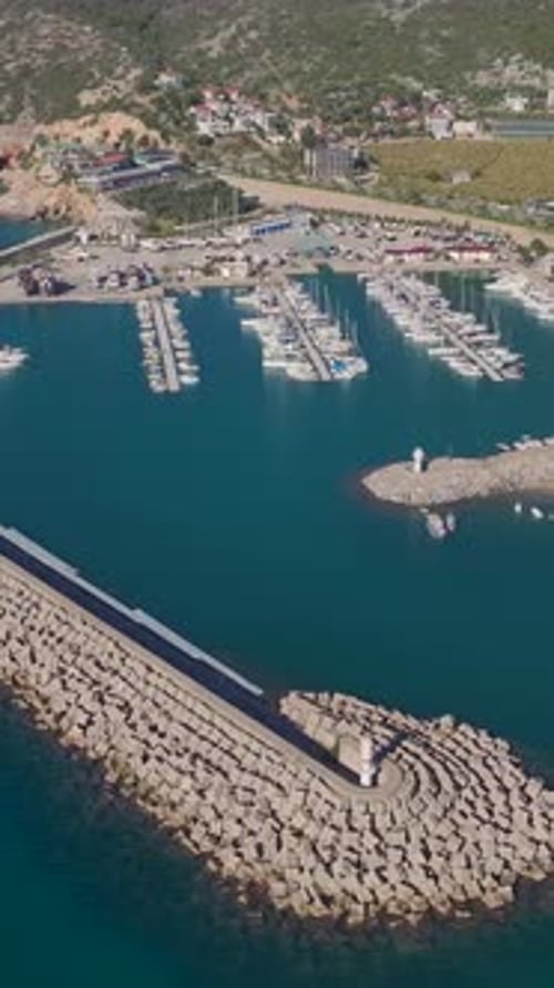 Vertical Video of Yachts Resting in a Port Surrounded By Sparkling Waters and a Clear Blue Sky