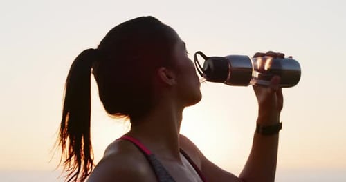 Sunset, athlete or woman drinking water on break after exercise, outdoor workout
