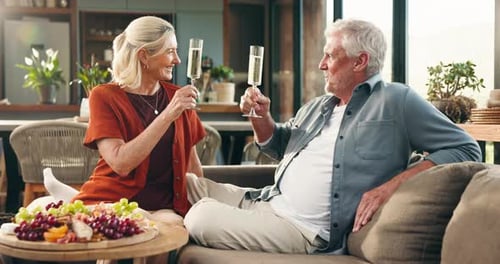 Senior Couple Toasts with Champagne at Home