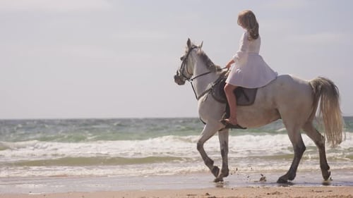 Girl In White Dress Horse Riding By The Beach