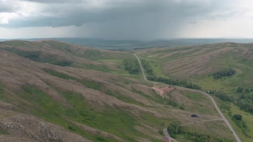 Rolling Hills and Distant Storms: Aerial View