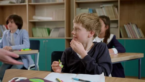 Elementary School Class Children Communicate with the Teacher Answering Question