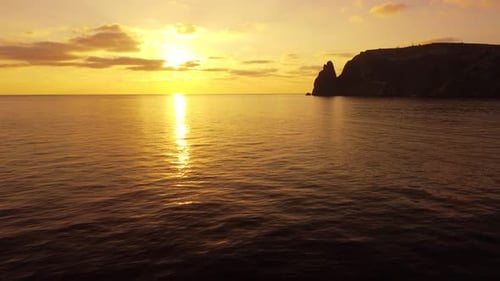Aerial View on Sunset Over Calm Sea and Volcanic Rocky Shores