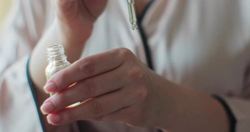 Close up of Hands Using Oil for Skin