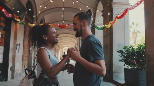 Feliz pareja interracial bailando al aire libre