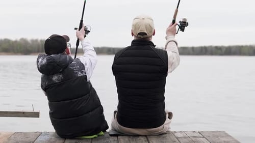 Father and son spend Father's Day fishing. Dad teaches his son how to fish.