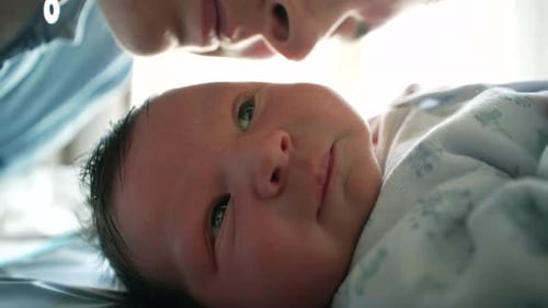 Close-up of a mother kissing her newborn’s cheek, sharing a loving and intimate moment. the deep