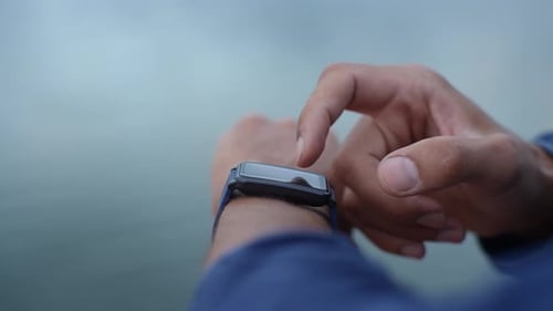 Close up of Hand Tapping Smartwatch Outdoors