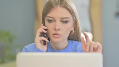 Close Up of Woman Talking on Phone while using Laptop