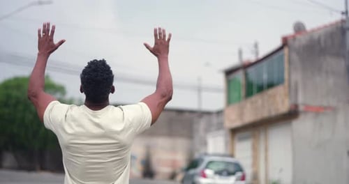 Man with arms raised to the sky in a gesture of spiritual joy and gratitude, expressing hope and