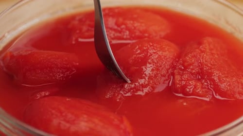 Canned Tomatoes Being Picked Up by a Fork