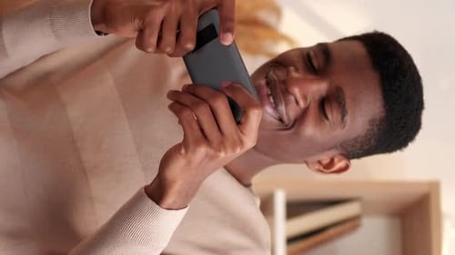 Young Adult Smiling While Using Smartphone