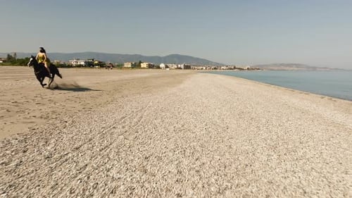 Woman Riding a Horse on the Sand