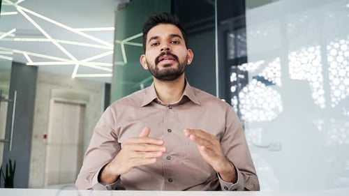 Webcam view. Confident businessman talking on a video call looking in camera sitting at workplace