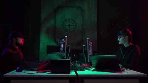 Hackers Typing on Computers in Dark Room