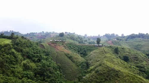 Aerial View green grass sky and clouds in nature Mountain trees forest at daylight.