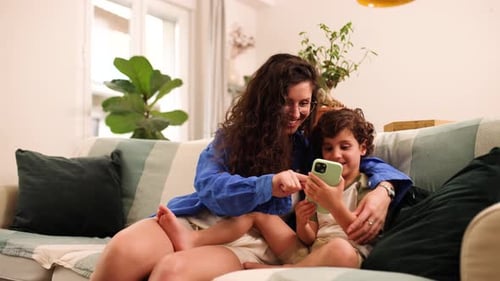 Mother and Child Using Smartphone on Couch