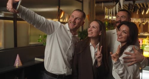 Four Happy Office Workers in Business Clothes Take a Selfie and Rejoice During a Fun Corporate Party