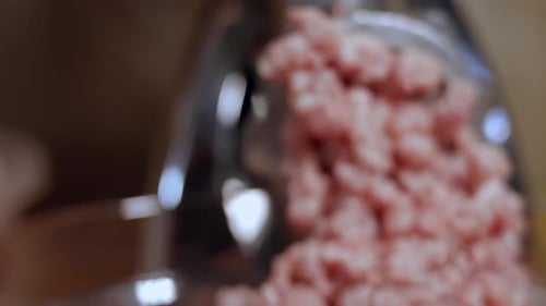 Closeup of Minced Meat is Scrolled Through a Meat Grinder Sieve