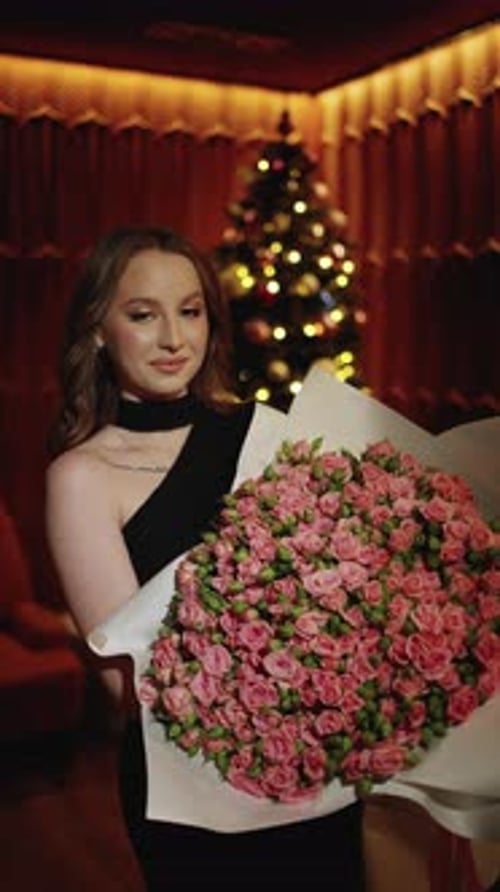 Woman Holds Pink Rose Bouquet Near Christmas Tree