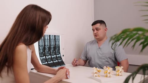 Doctor Consults With Patient About Spine X-Ray