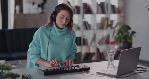 A Woman is Engaged in Work on Her Laptop in a Stylish and Cozy Home Office Environment