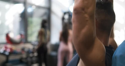 Man Exercising with Dumbbells While Working Out in the Gym