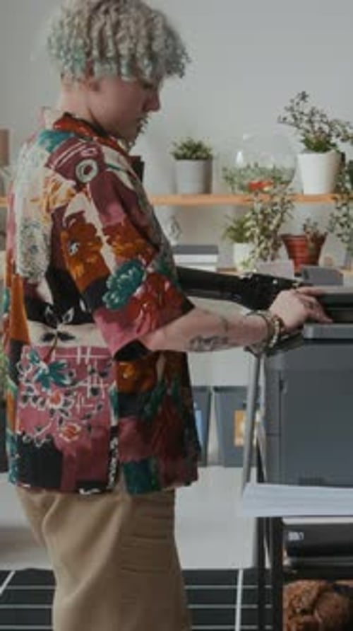 Empleado de oficina con brazo protésico escaneando un documento en una impresora multifunción