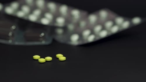 Yellow Pills Against Dark Background