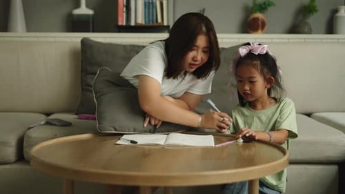 Young Adult Helping Child with Schoolwork Indoors