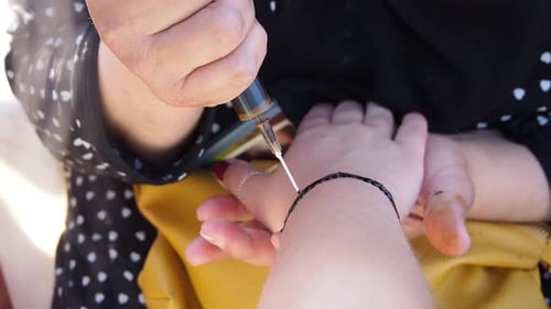 Woman Applies Henna Tattoo on Hand